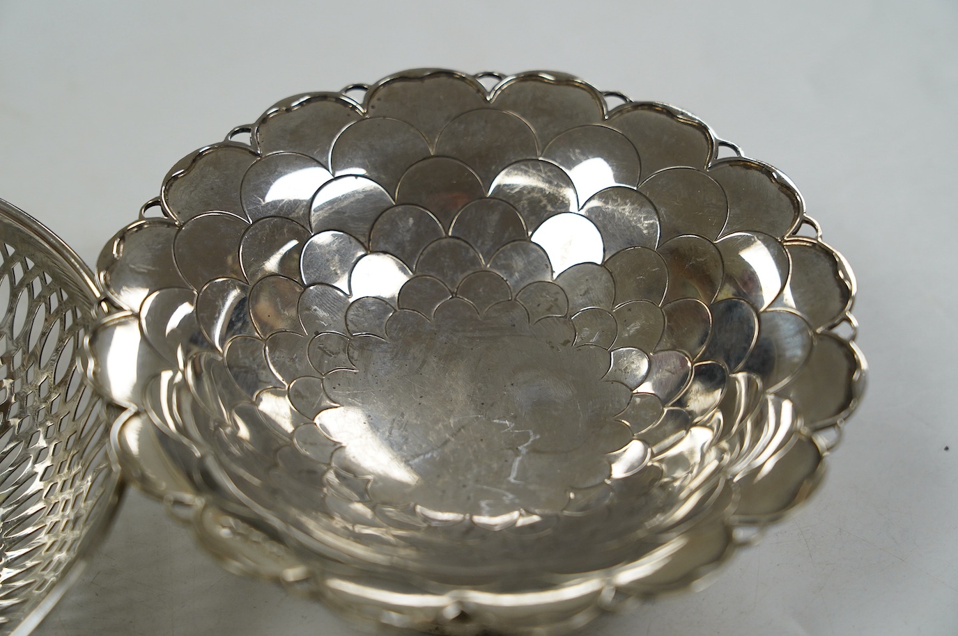 A pair of George V silver pedestal bonbon dishes, Birmingham, 1916, diameter 12.7cm, a set of four similar silver glass coasters, a silver bonbon bowl and a pair of Chinese white metal dishes with inset coin bases by Wan